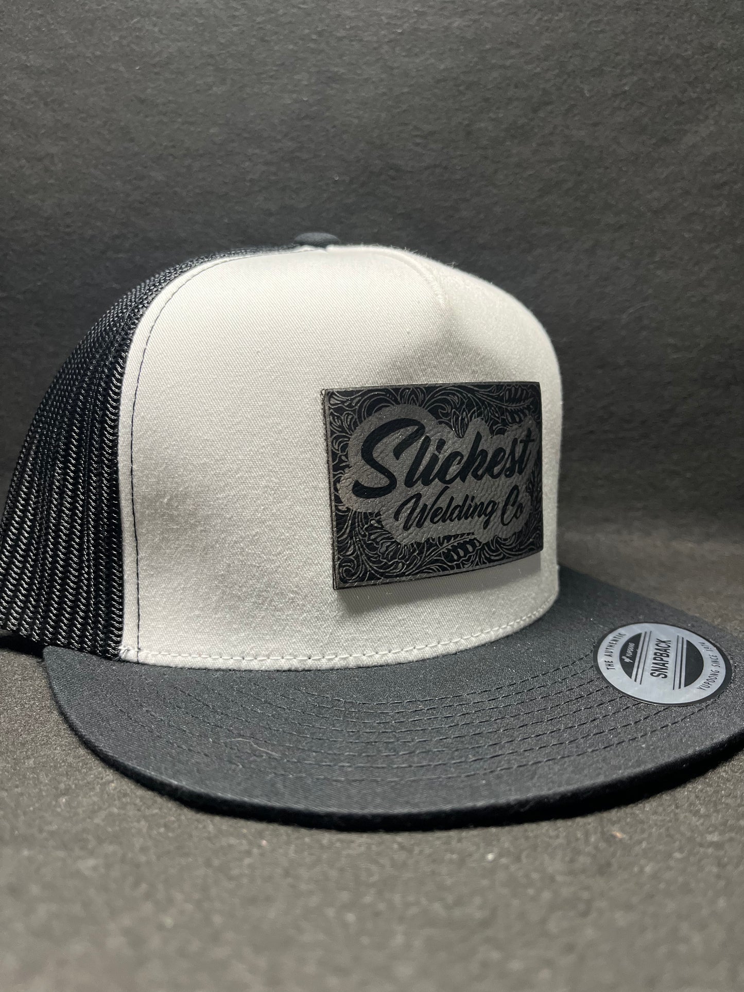 Black and white hat with a silver patch
