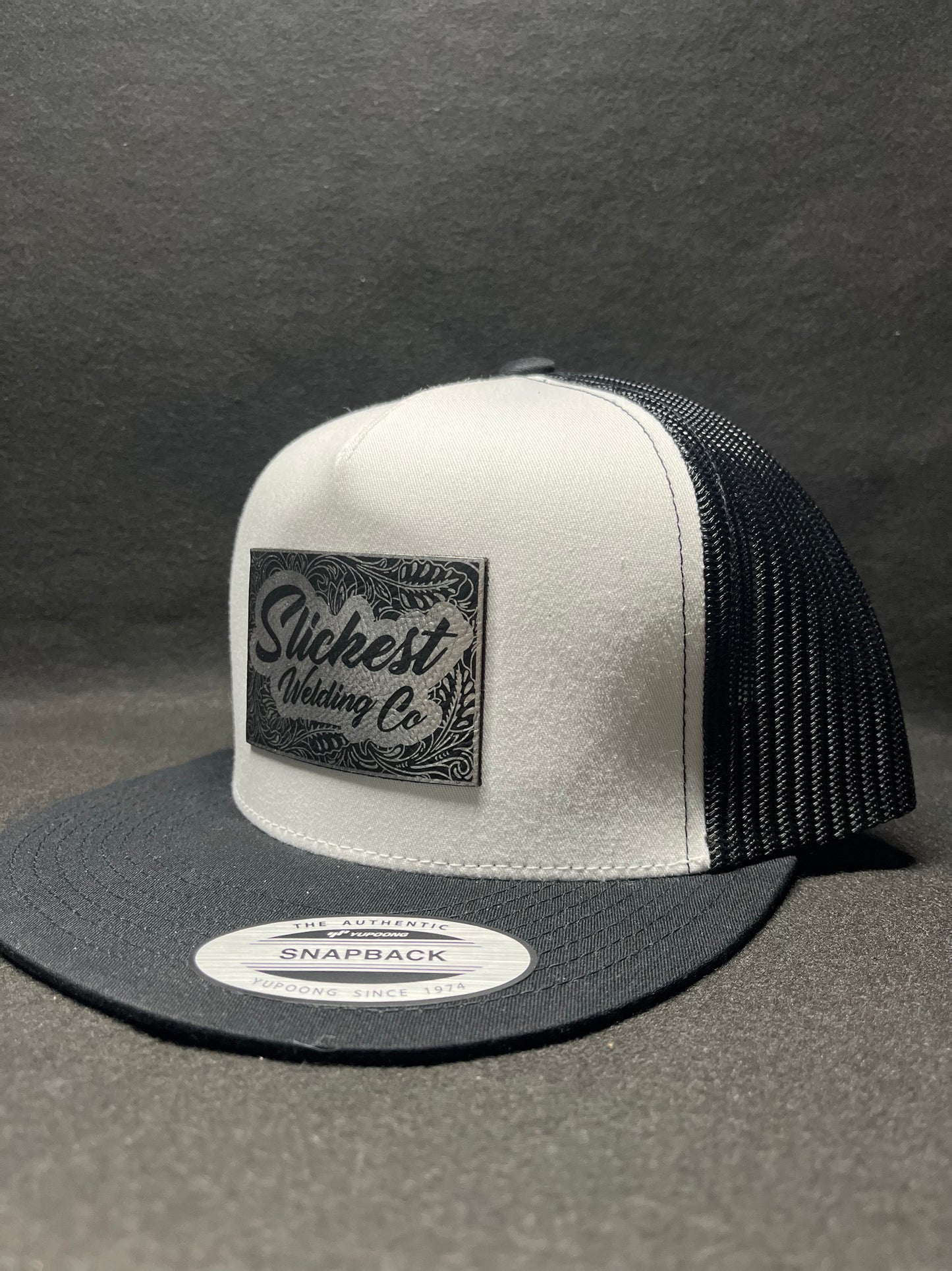 Black and white hat with a silver patch