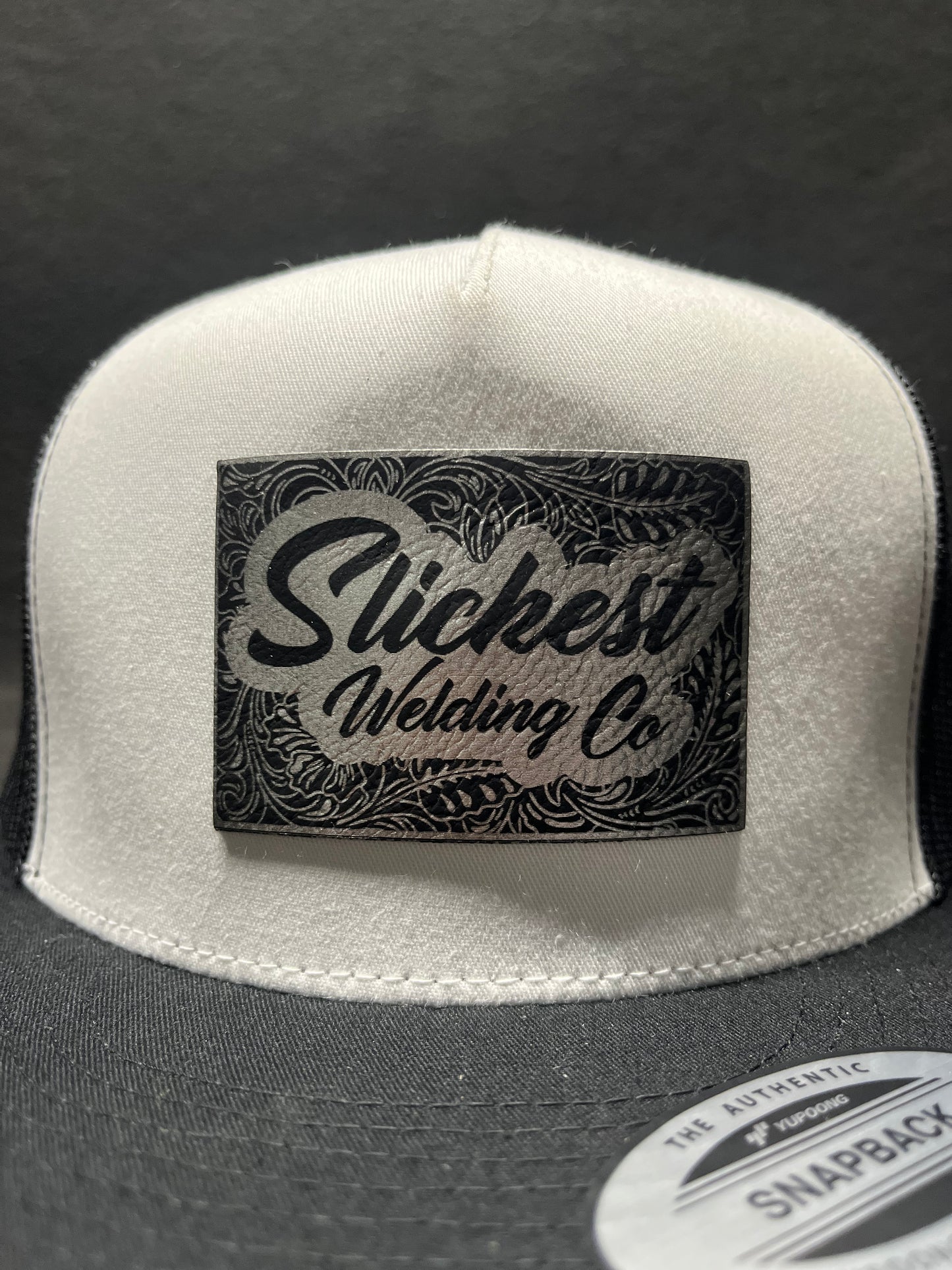 Black and white hat with a silver patch
